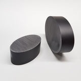 alt="two black resin oval plinths showing the flattened off face on each"