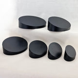 alt="black sloped oval plinths six variants"