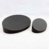 alt="black sloped oval plinths two examples"