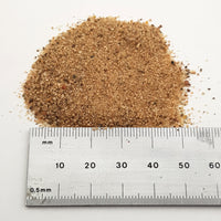 alt="Close up of smooth sand next to a ruler to give an impression of particle size"