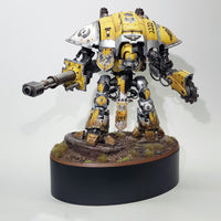 alt="painted yellow imperial knight on a scenic base mounted onto the largest of the oval plinths for reference"