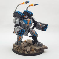 alt="tau broadside battlesuit smart missile pods assembled on a broadside along with missile pod arms, fully painted in a grey blue and orange scheme with additional modelled firing missiles"