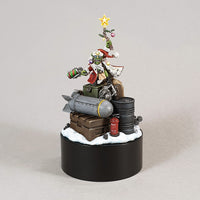 alt="Round Black plinth with a painted red gobbo model standing on a pile of ammo crates"
